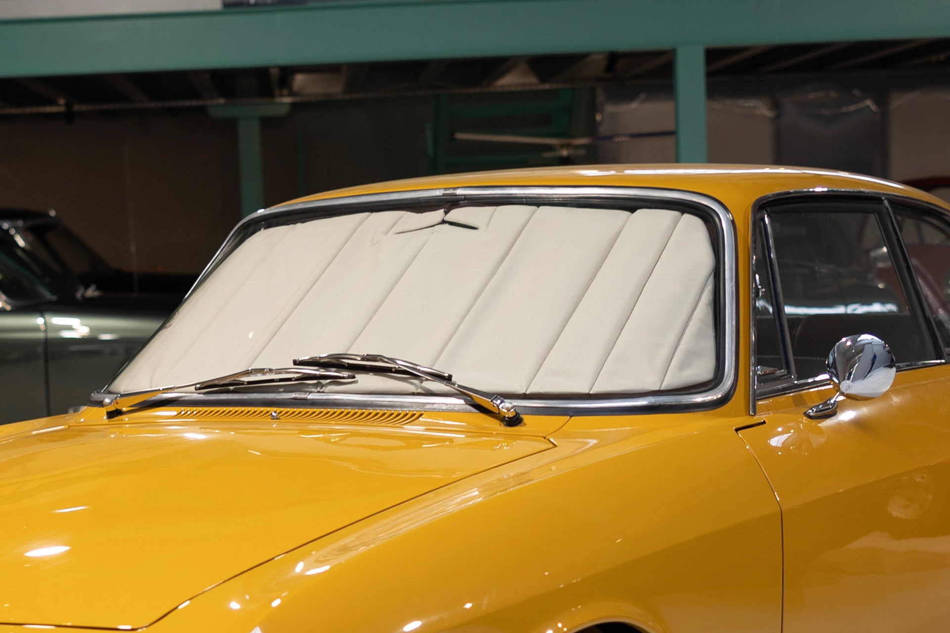 Front view of a yellow classic car featuring a standard premium sunshade, highlighting precision craftsmanship and tailored design for vintage vehicles. Autentici sun shade for car windshield. Protetor solar para para-brisas de automóvel clássico.