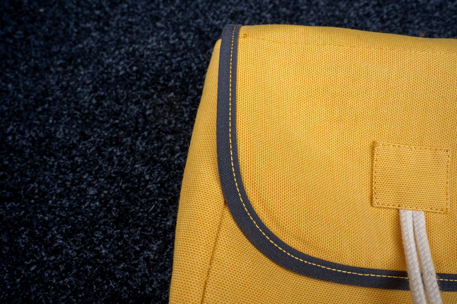 Close-up of a premium yellow storage bag with reinforced stitching and contrasting trim, designed for classic car sunshade protection.  Autentici sun shade for car windshield. Protetor solar para para-brisas de automóvel clássico.